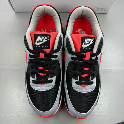 Nike Air Max 90 black trainers with radiant red and wolf grey accents, logo detail.
