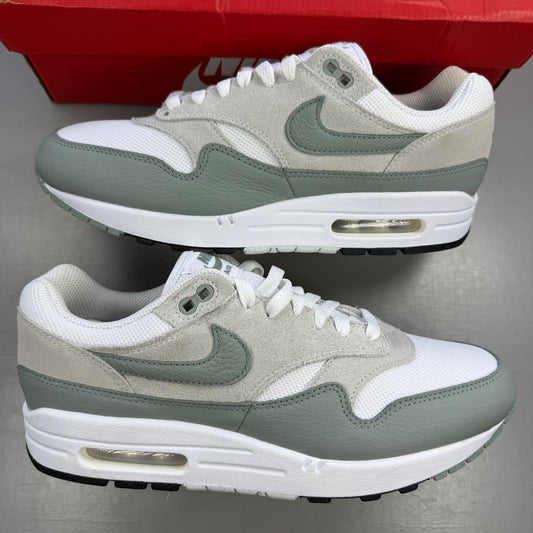 Nike trainers white with grey accents and green detailing, featuring iconic swoosh logo.