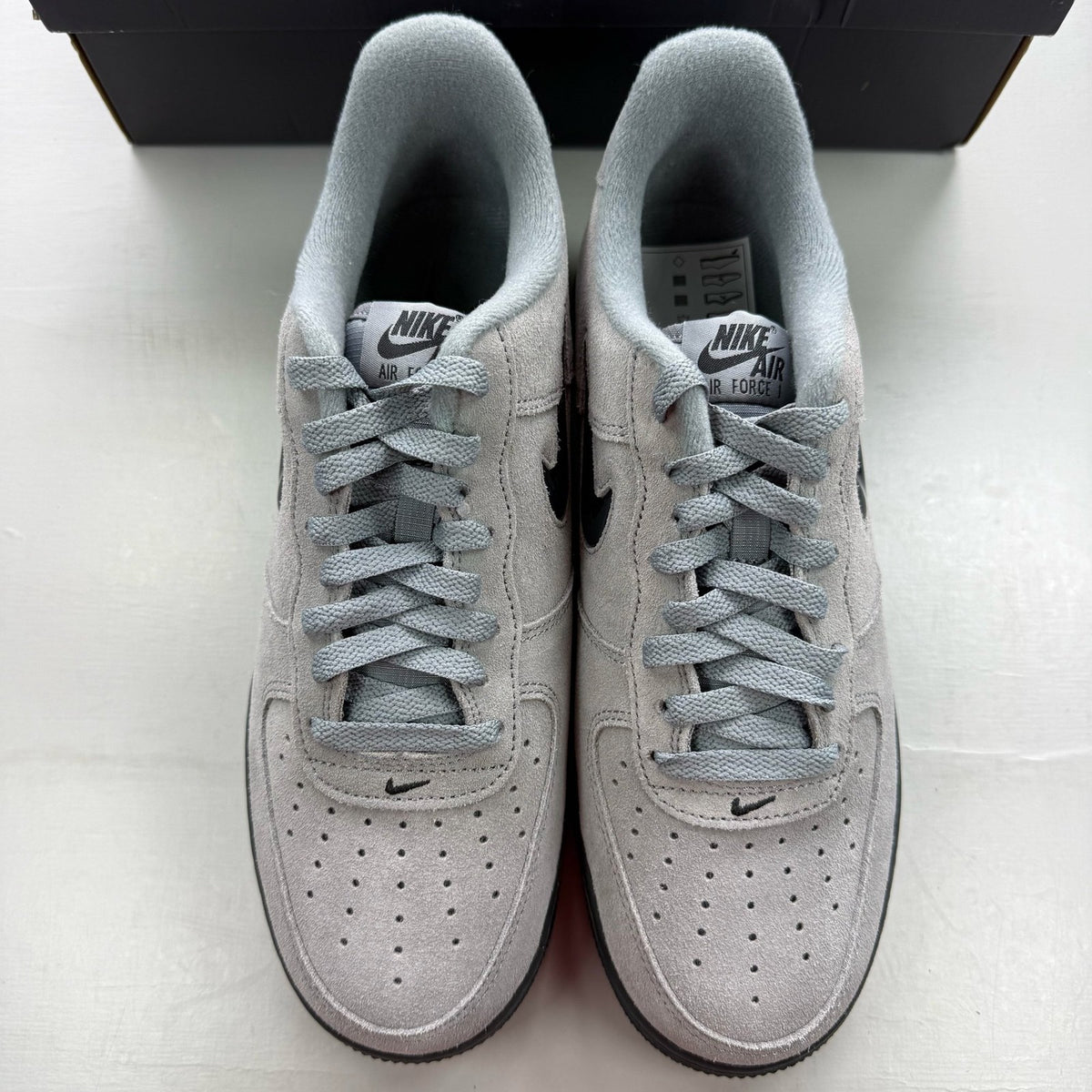 Nike Air Force 1 Low Jewel grey trainers with black accents and signature swoosh logo.