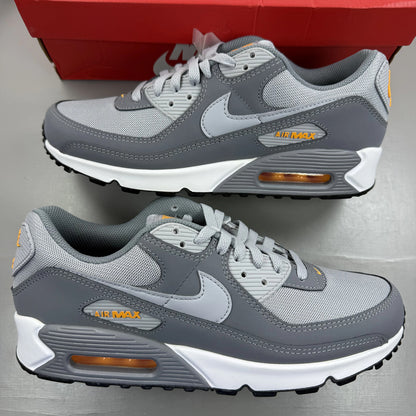 Nike Air Max 90 grey trainers with black and sundial accents, featuring logo details.