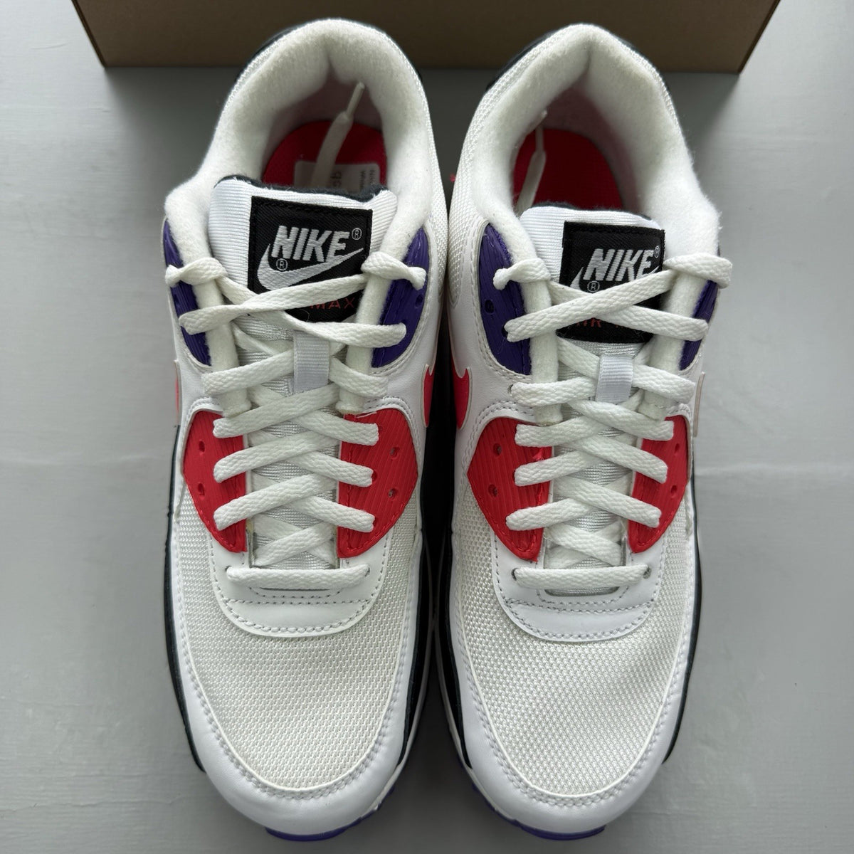 Nike Air Max 90 Raptors white trainers with red, purple, and black accents.