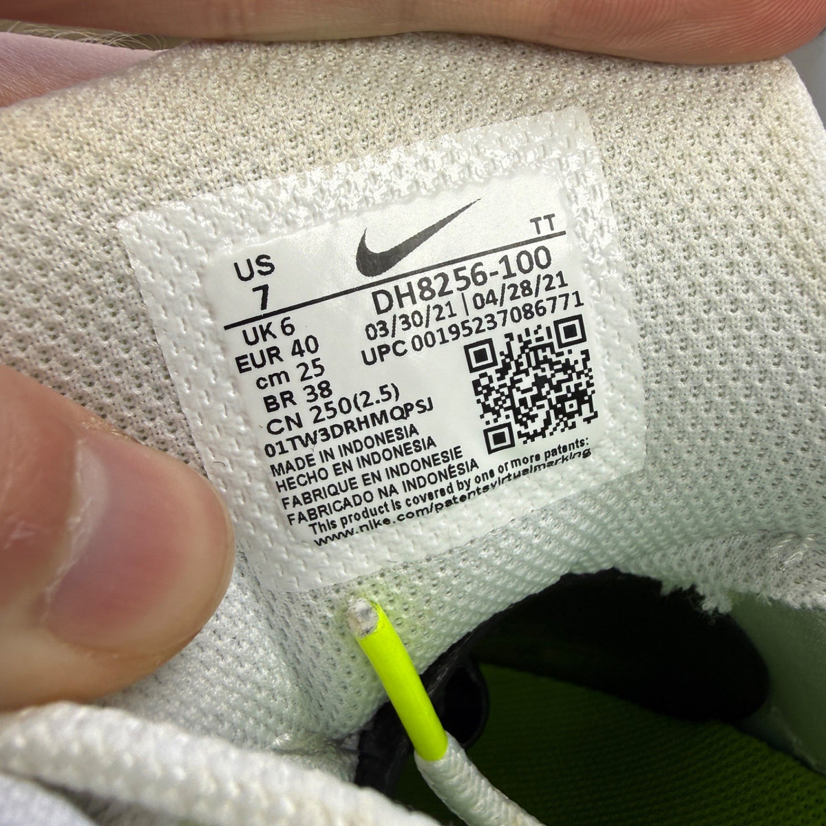 Nike trainers white with neon grey volt accents and retro logo details.
