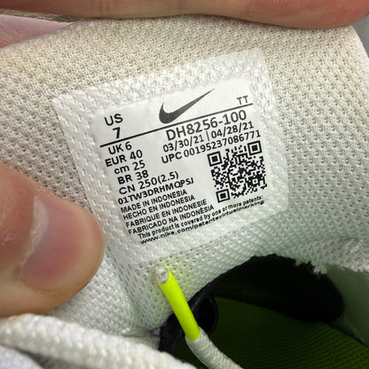 Nike trainers white with neon grey volt accents and retro logo details.