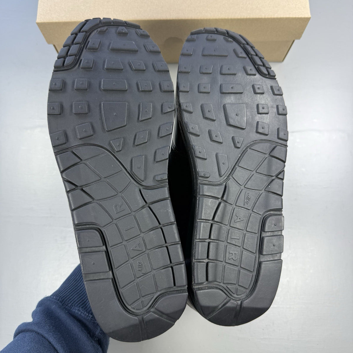 Nike black Air Max 1 Essential trainers with signature swoosh logo and mesh detailing.